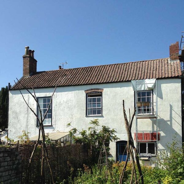 Chimney repairs and window 'eyebrows' repaired in lime render (sheets protecting new lime from the sun).