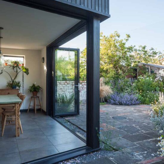 Double bifold doors link interior and exterior spaces in the summer